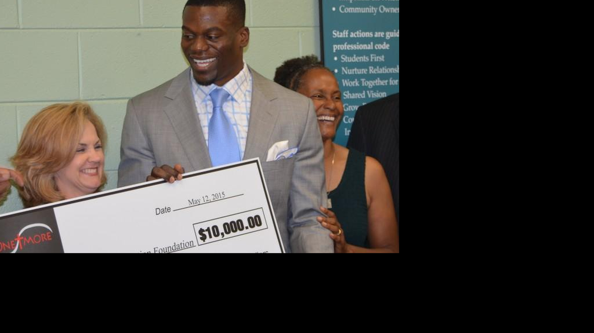 In this May file photo, Superintendent Kelly Pew, left, is shown receiving a ceremonial $10,000 check to the Rock Hill Schools Education Foundation from NFL tight end Ben Watson. Pew will recommend to the school board in January an increase in athletic funding for the district’s three high schools.