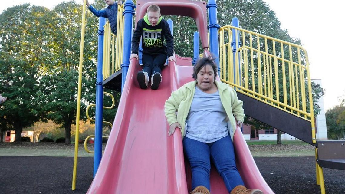 Jessica Poole, 21, right, and Justin Poole, 12, fly down a slide at Winthrop Park in Rock Hill, while J.T. Poole plays near a pole. Winthrop Park will transform into Miracle Park, an athletic and play park for people with disabilities and special needs.