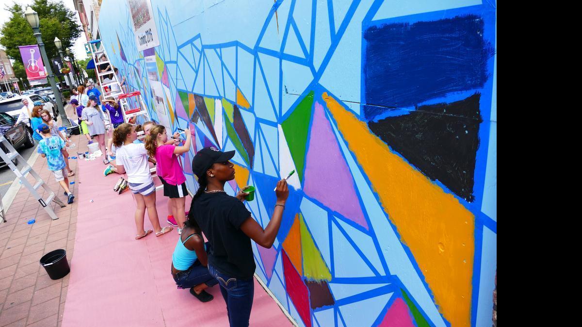 
South Pointe High and Ebinport Elementary students work on a mural at the future site of the Woolworth Walkway in downtown Rock Hill.
