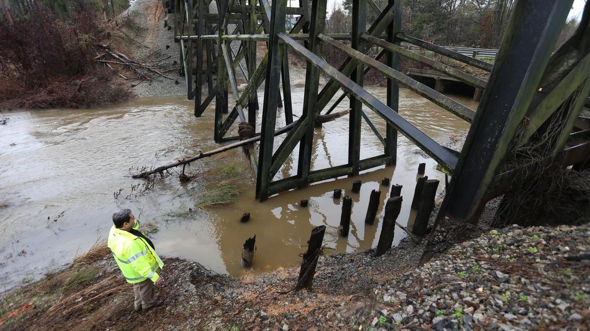 A DHEC dam inspector looks over a dam near Farrow Road in Northeast Columbia on December 22, 2015, after heavy rains filled the lake with water and caused it to spill over the top.