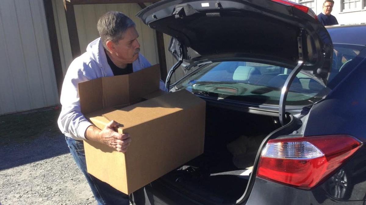 Mark Cole of the York County Fraternal Order of Police loads a car Monday with food the group donated to the needy.