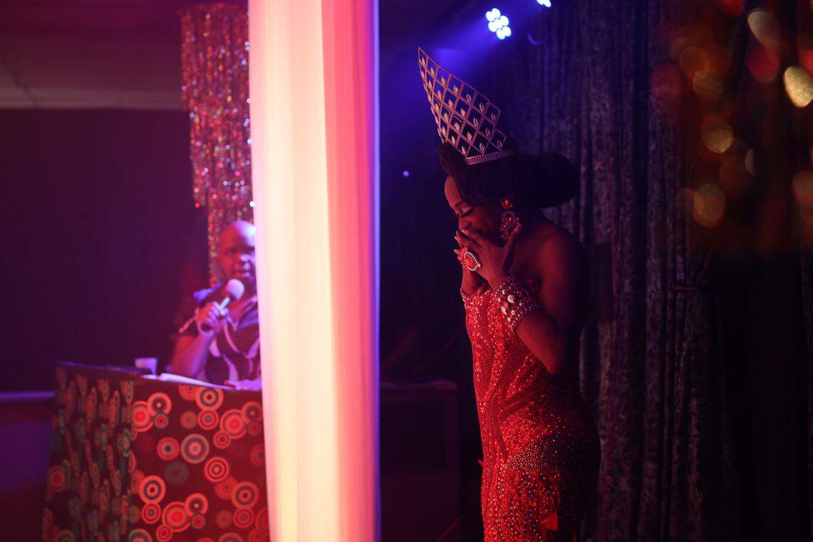 A drag queen beauty pageant winner cries behind the curtain before she makes her way to the stage.