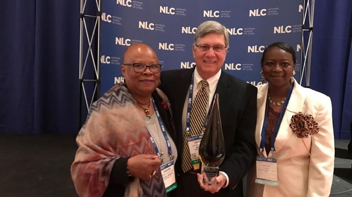 Rock Hill Mayor Doug Echols, center, holds an award from the National League of Cities with fellow city council members Sandra Oborokumo, left, and Ann Williamson, right.