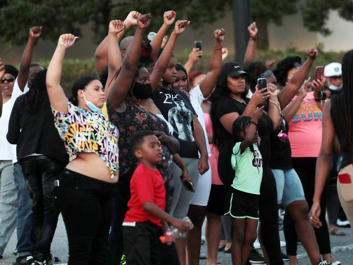 Protesters raise their arms Wednesday in downtown Rock Hill.