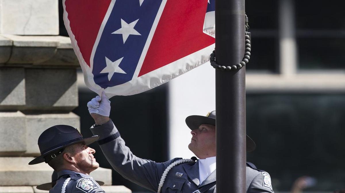 
An honor guard from the South Carolina Highway Patrol lowers the Confederate battle flag as it is removed from the Capitol grounds Friday, in Columbia. The Confederate flag was lowered from the grounds of the South Carolina Statehouse to the cheers of thousands on Friday, ending its 54-year presence there and marking a stunning political reversal in a state where many thought the rebel banner would fly indefinitely.
