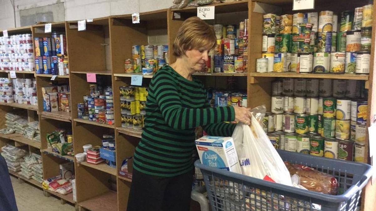 Pilgrims’ Inn volunteer Judi Nase fills food bags for needy clients at the Rock Hill charity.