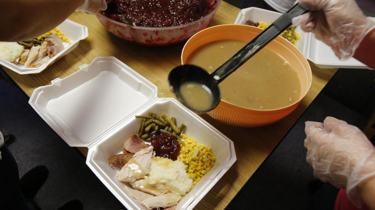 St. Anne Catholic Church in Rock Hill prepares Thanksgiving meals for those in need. Sandra Hernandez ladles gravy on meals being assembled for delivery.