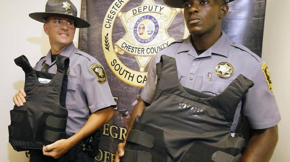 
Chester County Sheriff’s Deputy Cedric Dunn, right, shows off a new bulletproof vest that was paid for by private donations last month. 
