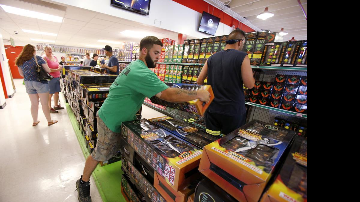 
People buying fireworks for July 4th at Area 51 fireworks next to Carowinds and Frugal McDougal near the state line. Crew member Kevin Campbell stacks fireworks at Area 51. 

