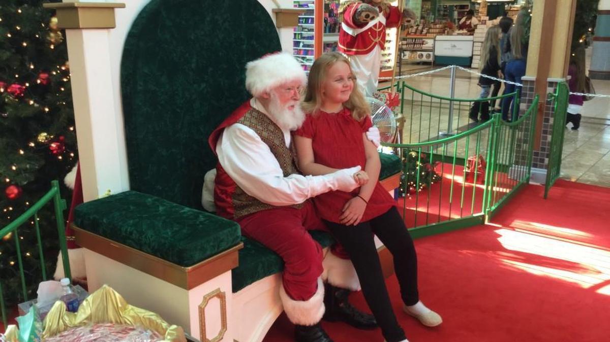 Nine-year-old Elizabeth Wiley sits on Santa Claus’ lap at the Rock Hill Galleria.