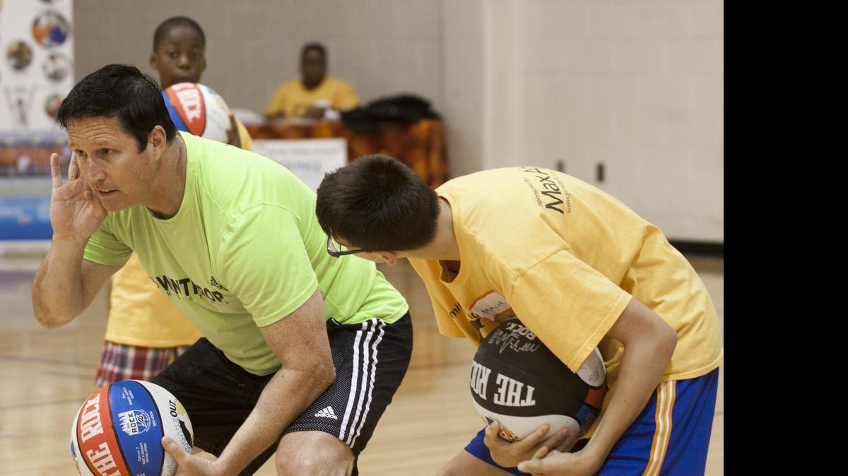 
Winthrop University’s assistant basketball coach Marty McGillan works with Maguire Davis Thursday at the Bounce Out the Stigma basketball camp. The York County Board of Disabilities and Special Needs sponsored the event.
