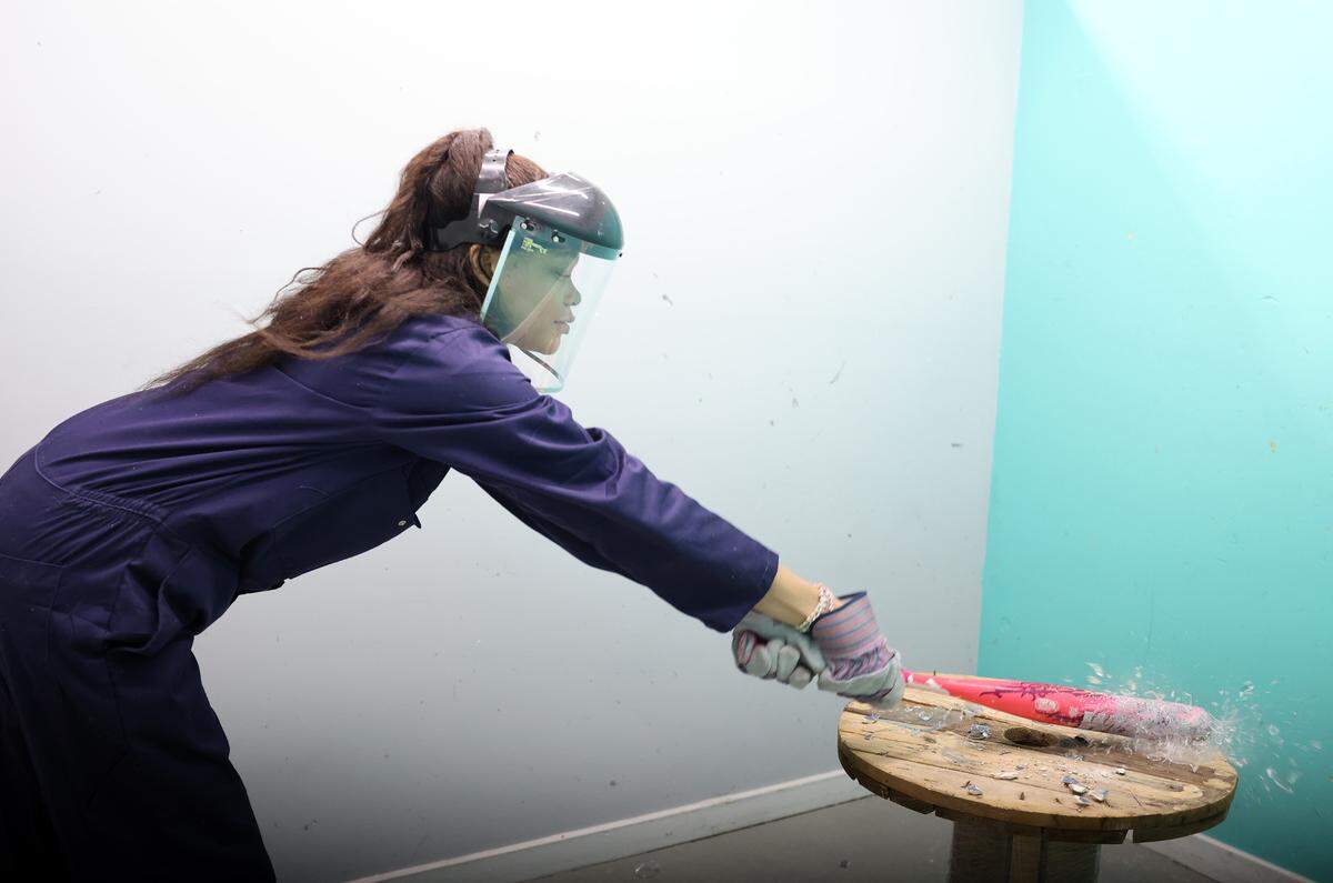 Tyliya Moses, smashes glass at T-Wrecks Smash and Paint Splatter Room in Rock Hill.