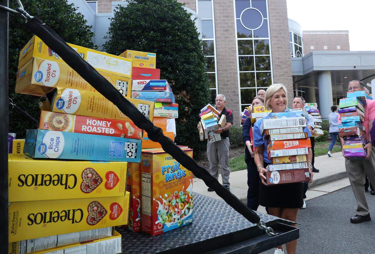 Teresa Urquhart, market CEO of Piedmont Medical Center, center, helps load boxes of cereal into a truck Tuesday at Piedmont Medical Center in Rock Hill. The hospital held its Healthy Over Hungry Cereal Drive in June.