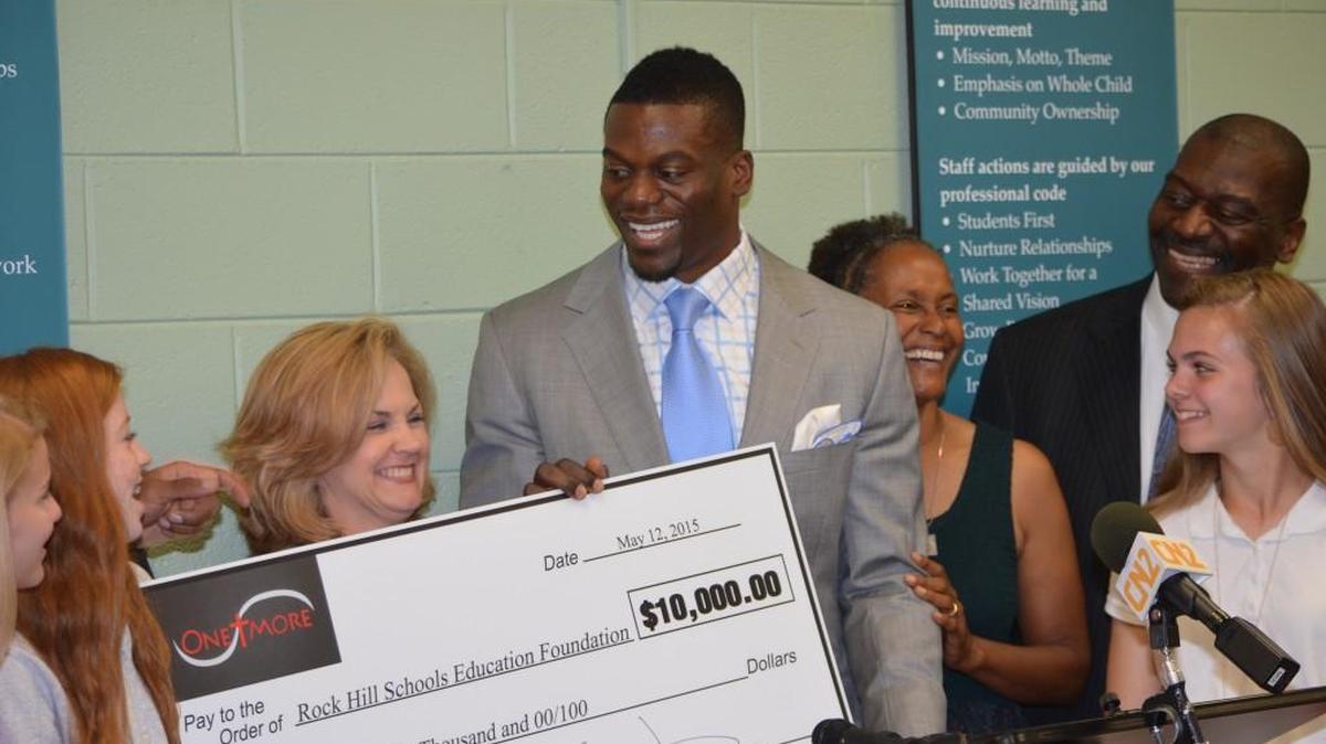 Ben Watson, his parents Ken and Diana, Kelly Pew, Rock Hill Superintendent of Schools, and others react to his $10,000 donation to the Rock Hill Schools Educational Foundation.