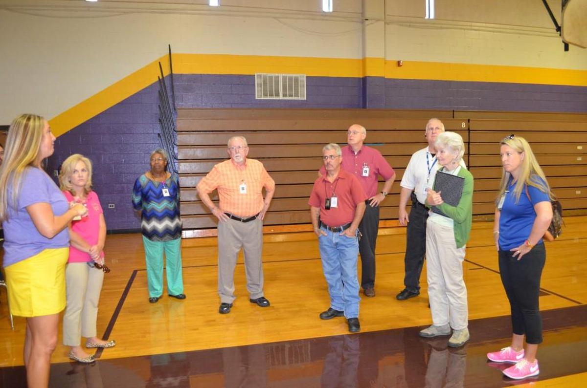 Northwestern High School athletic director Lauren West, left, explains to the school board and administration the need to air condition its older gyms. The gyms often become too hot to use for classes, she said. 