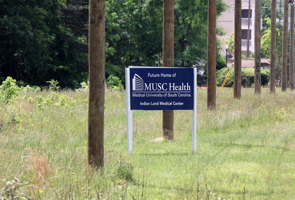 A sign visible from U.S. 521 lets drivers know the Medical University of South Carolina will build a medical center on the site. The hospital will open after a medical office building beside it, with both delayed from earlier plans.