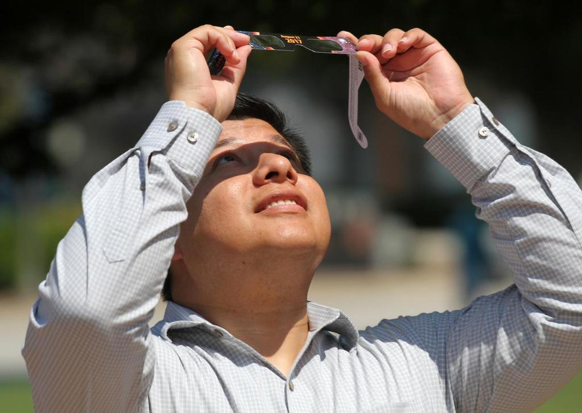 A man looks through a pair of special glasses Monday during the solar eclipse in downtown Rock Hill.