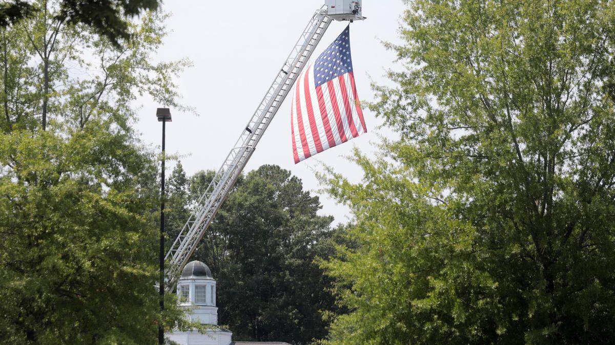 Nearly three years after the murder, the court case changing Evan Robert Hawthorne with killing Larry Vaughan still hasn’t gone to trial. In this 2021 file photo, a large American flag flies from a fire engine at Vaughan’s funeral.
