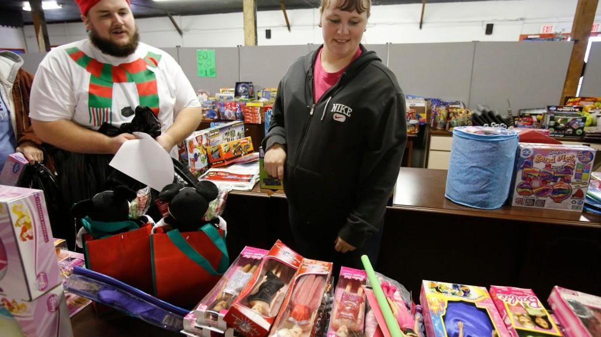 Tender Hearts Ministries in York held their food and toy giveaway to the needy Friday. Food and toys were supplied by a community donation campaign. Volunteer Ronnie Richardson from Elevation Church, left, helps Beverly Ortiz pick out toys for her four children, ages 7, 6, 4 and 1.