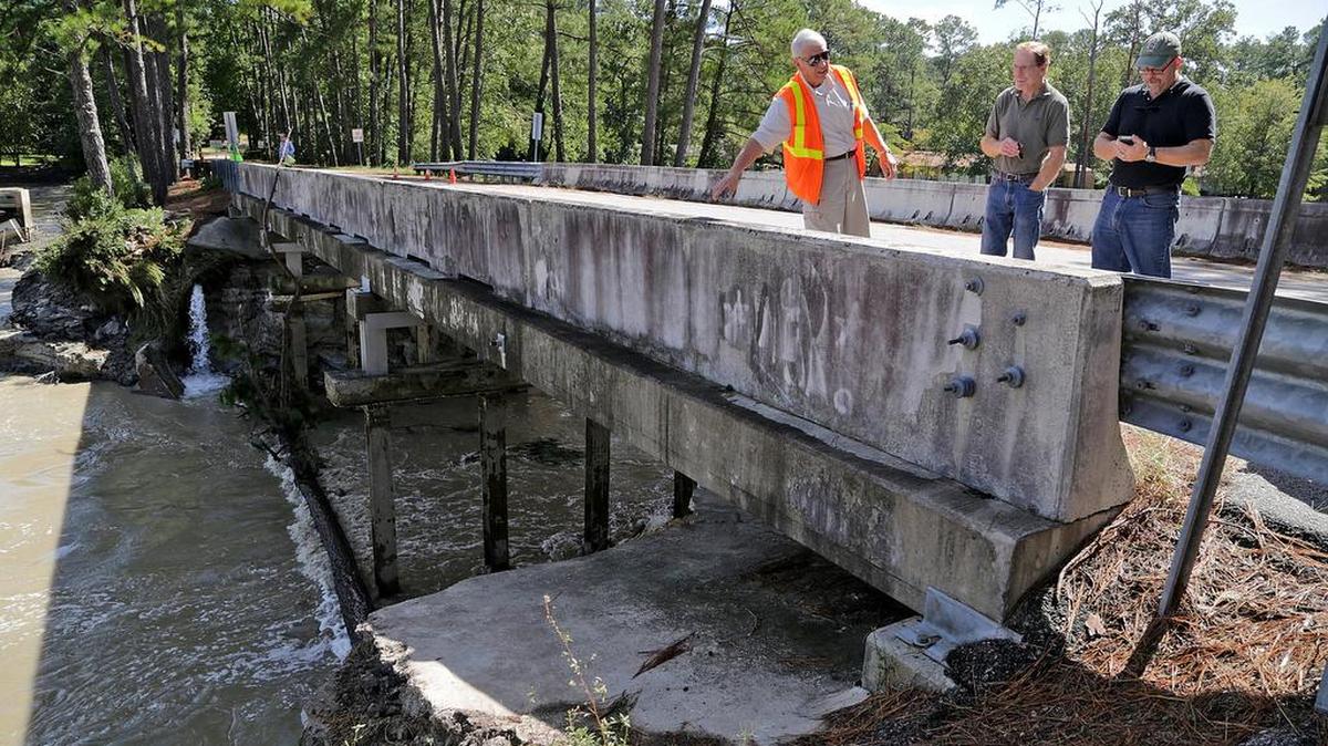 
Grady Adkins, Todd Chambers and Tom Teuber, president of the Upper Rockyford Lake Homeowners Association, survey the dam at Overcreek Road in Columbia on Tuesday.
