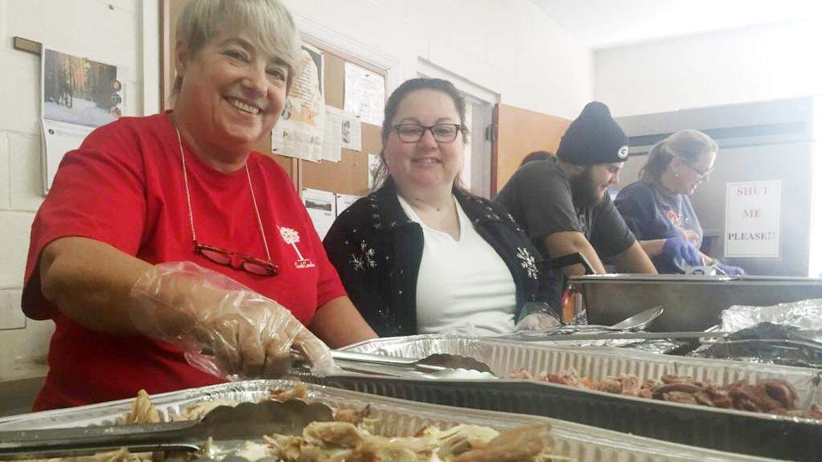 Dorothy Day Soup Kitchen volunteers work to hand out meals.
