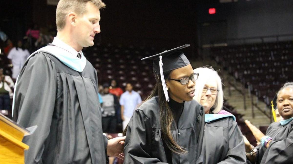 Donzhane Smith, center, wearing the graduation mortar board hat, whose battle with cancer left her in a wheelchair, rose and walked across the stage for graduation from York Comprehensive High School in May. Smith died from cancer Saturday at age 18.