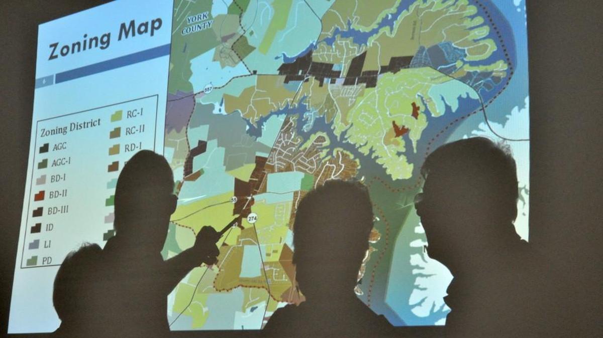 
In this June 25 file photo, Lake Wylie residents Jean and Bob Hojnaski and Jim and Ann Pugh talk about the areas zoning map shown on an overhead projector during a meeting at Crowders Creek Elementary School. The meeting, held by York County Planning and Development services, is one over several planned to seek public input about Lake Wylie's future land-use plan.
