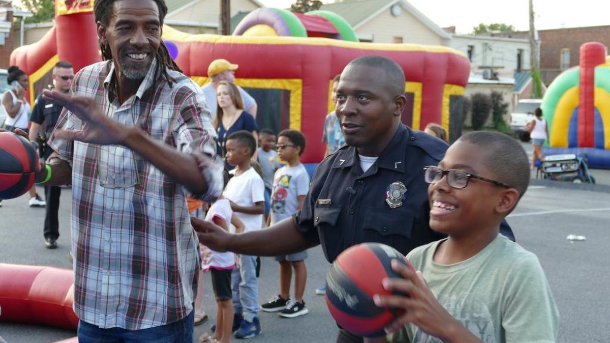 
Chanse Hamilton, right, gets coaching from York Police Officer Pierre King to beat his grandfather Steve Love at a game of hoops Tuesday night. Basketball was one of several games available at York’s celebration of National Night Out, a nationwide campaign that seeks to improve police-community relations while also providing information to residents to make neighborhoods safer. 
