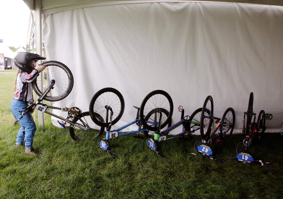 Irelyn McGinley, 8, picks up her bike Monday at the BMX World Championships in Rock Hill.