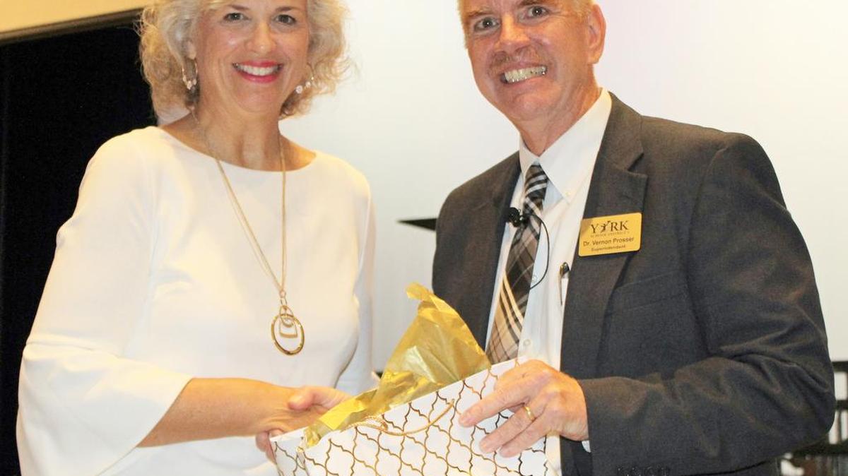 Dr. Vernon Prosser, superintendent of York School District One, honors Debbie Lancaster, sixth-grade English language arts teacher at York Intermediate School, as district Teacher of the Year during the back to school celebration Friday.