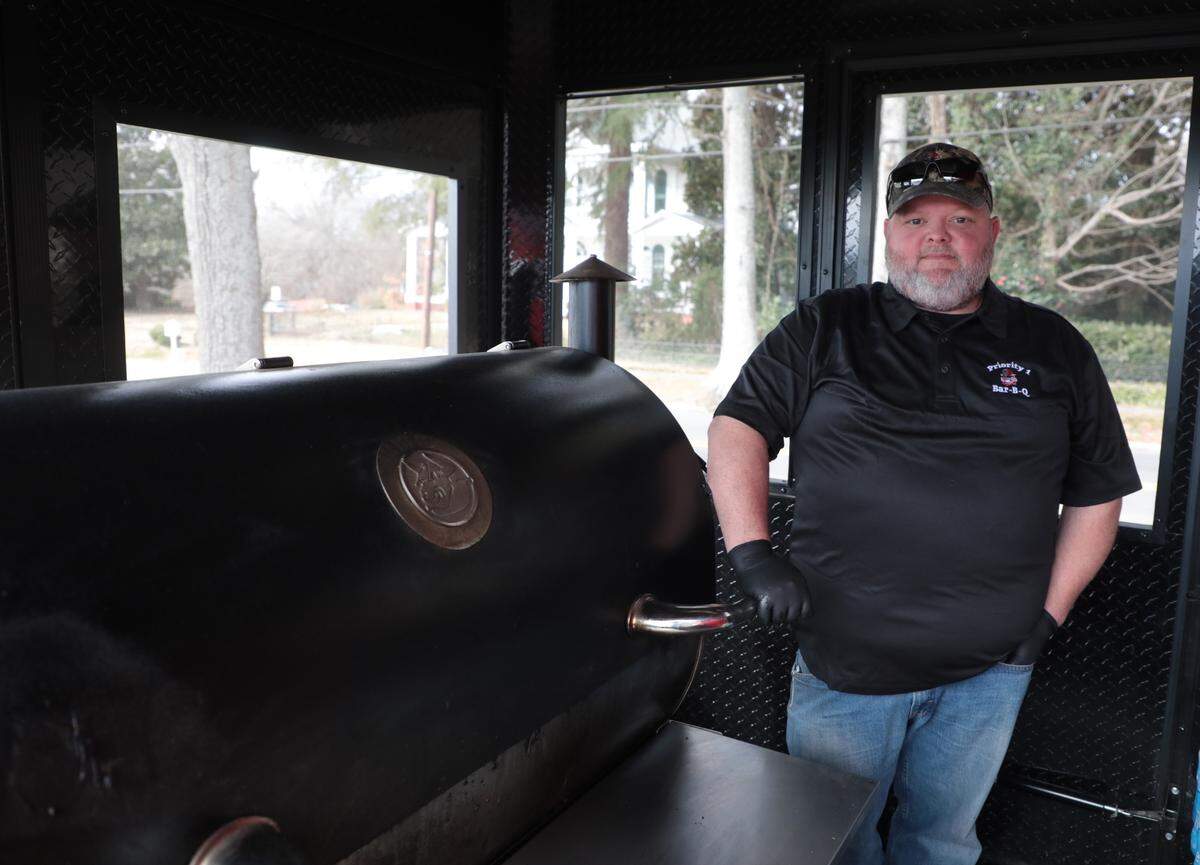 Michael Loss of Rock Hill stands near a cooker on his food truck, Priority 1 Barbecue.