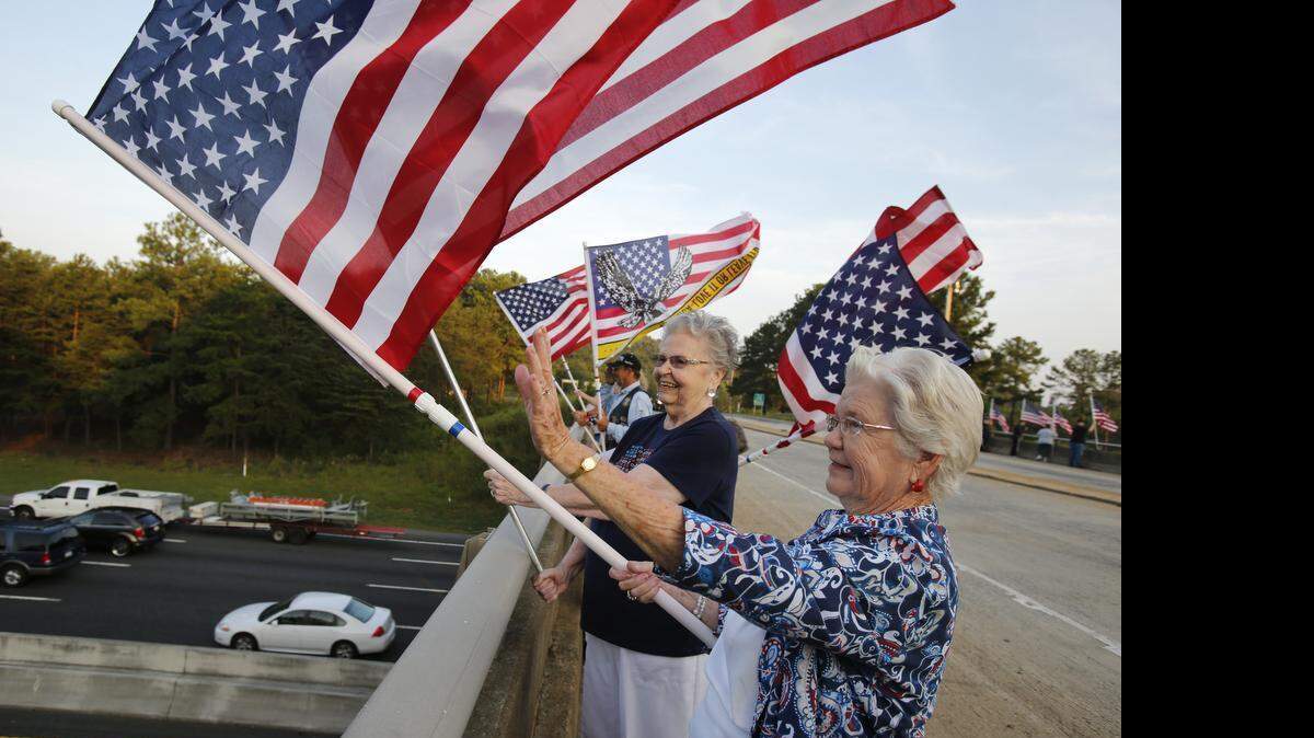 
Members of Rolling Thunder and others were waving American flags Thursday morning, September 11, 2014 on the Sutton Road bridge over I-77 in Fort Mill, S.C. to mark the anniversary of the 9/11 attacks. Pictured are Betty Farrington, left, and Alice Crocker, right, wave flags. Betty Farrington's late husband Leonard Farrington, a World War II Navy veteran, went out to the Sutton Road bridge over Interstate 77 on the day of the attacks in 2001 and waved his American flag to show that terrorists do not beat America.
