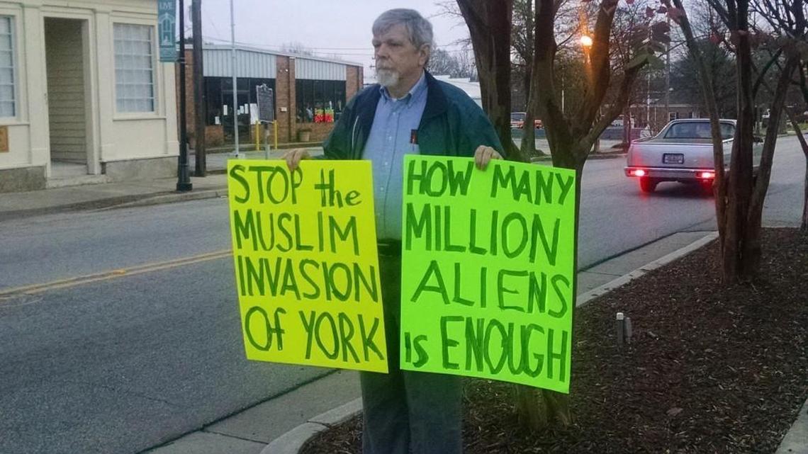 Nelson Waller of Anderson holds signs outside York County’s administration building on Monday, just before the county council voted on a resolution opposing the resettlement of Syrian refugees.