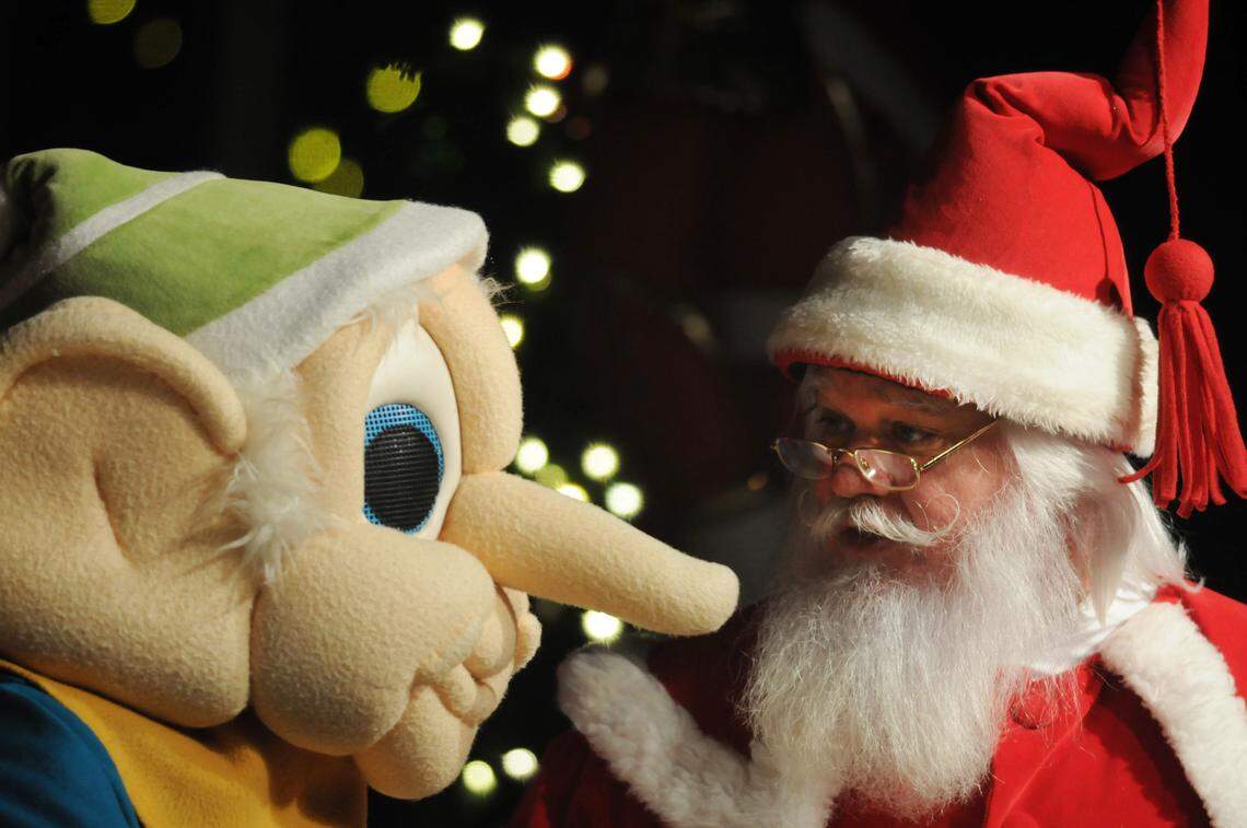 Santa talks to a Vernon Grant gnome during the opening ceremony of ChristmasVille.