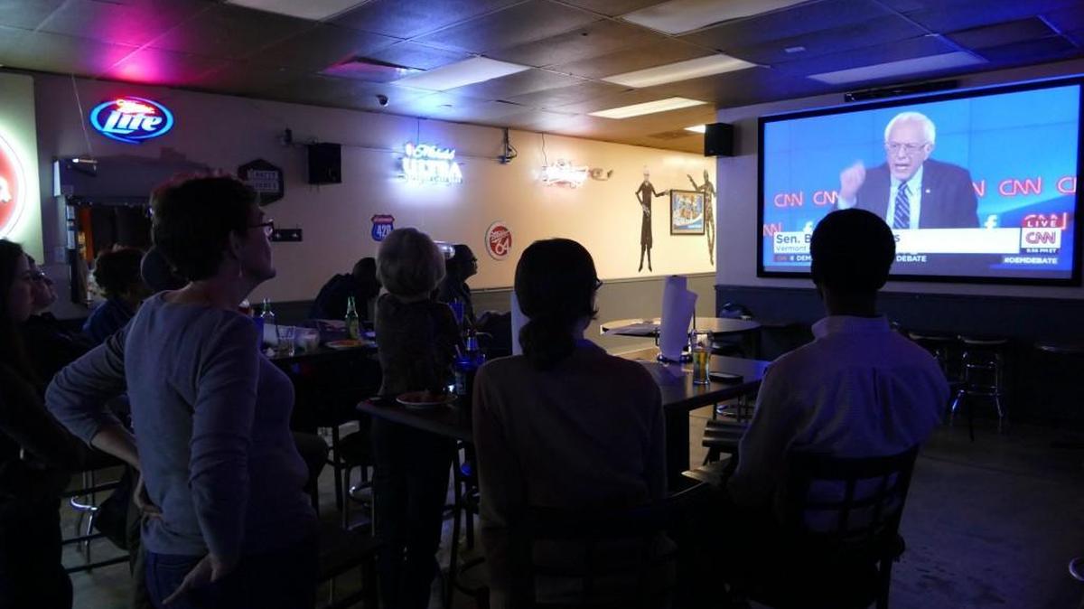 
Local supporters of Hillary Clinton watch her main opponent, Sen. Bernie Sanders, speak during Tuesday’s debate.
