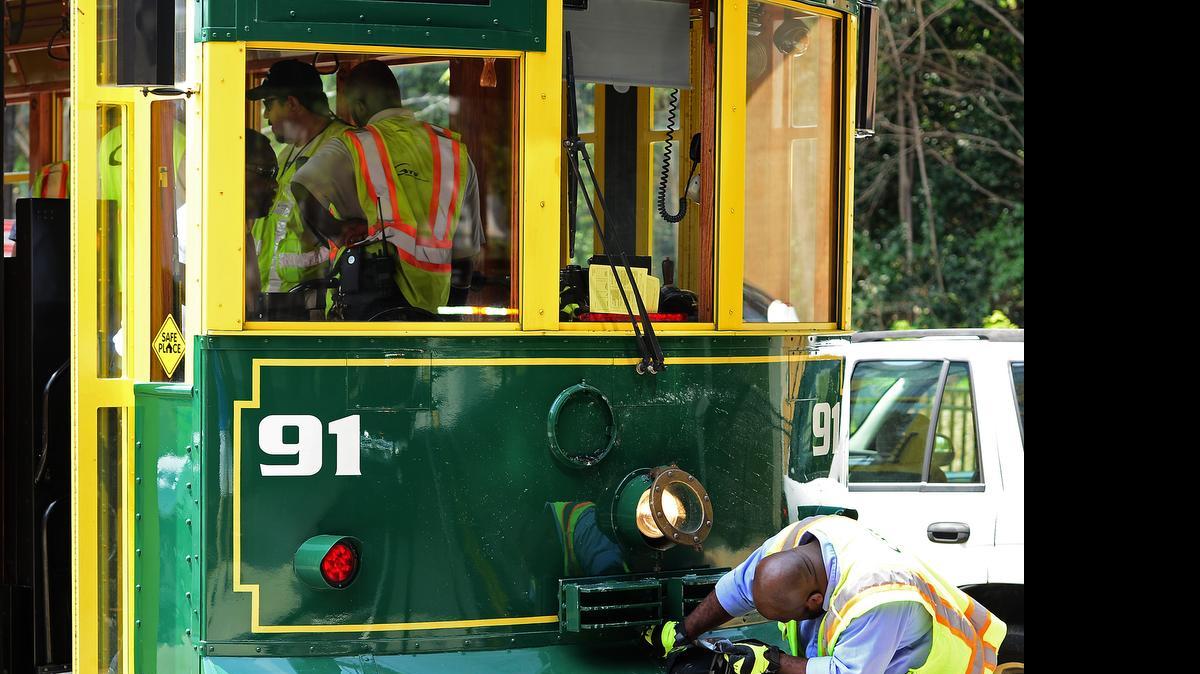 
A worker examines and cleans up the front end of a streetcar on Saturday, July 18, 2015 after it was involved in an accident with a SUV. The incident occurred around 10:30 a.m. when the streetcar rear-ended a sport utility vehicle. The cause of the accident remains under investigation. CATS spokesperson Olaf Kinard said it's the first accident involving the new streetcar line. 
