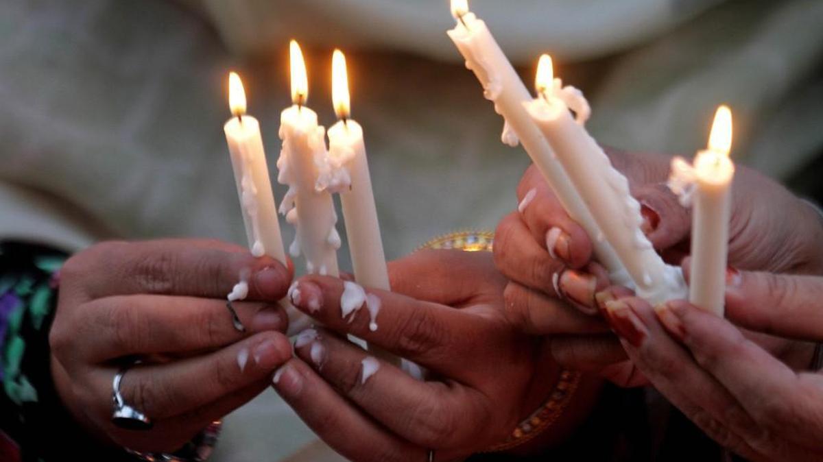 Pakistani women hold candles during a vigil for victims who were killed in Friday's attacks in Paris, outside French Consulate in Lahore, Pakistan, Monday, Nov. 16, 2015.