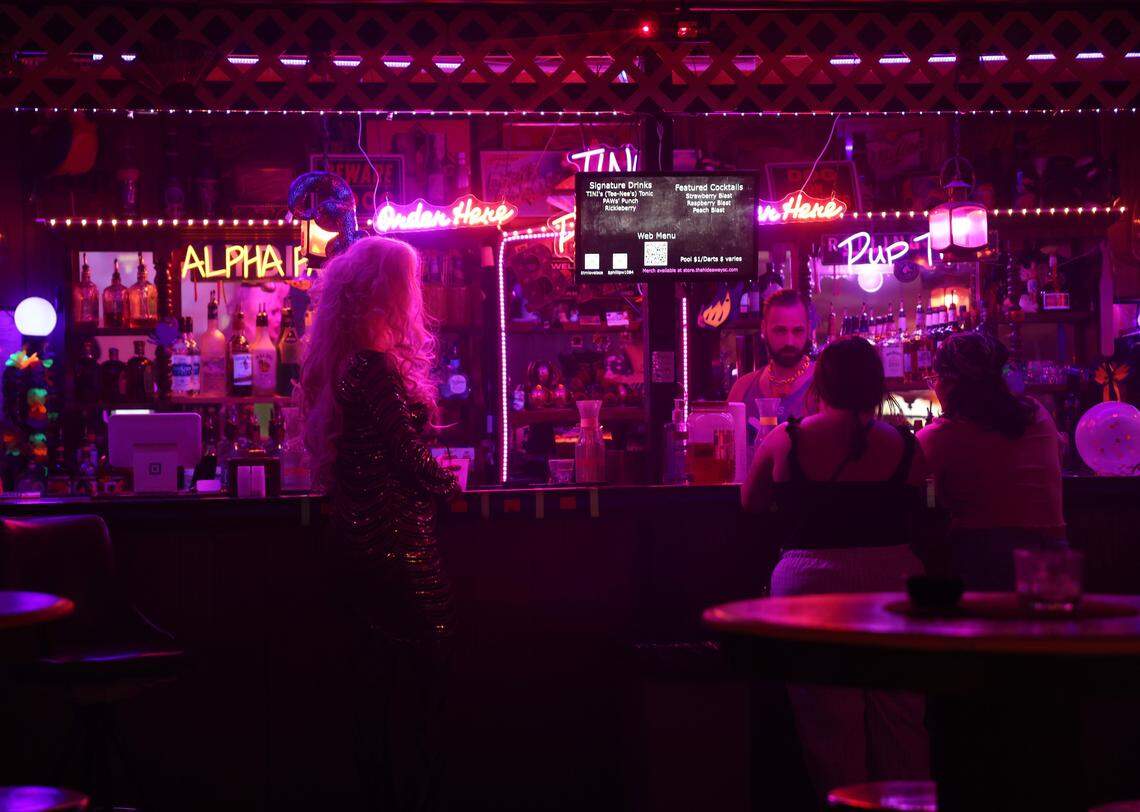 Drag queen Seveene Eleveene stands at the bar at The Hideaway in late January in Rock Hill, S.C.