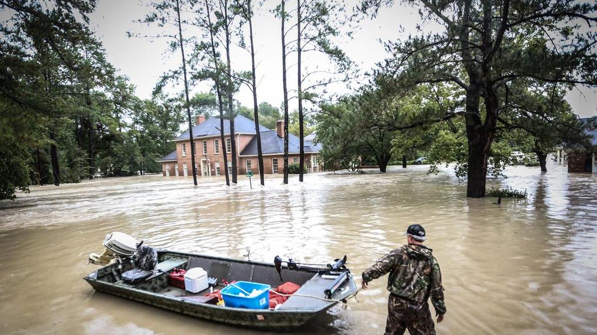 A Forest Acres resident pulls his boat onto Forest Ridge Lane, which was submerged in flood water.