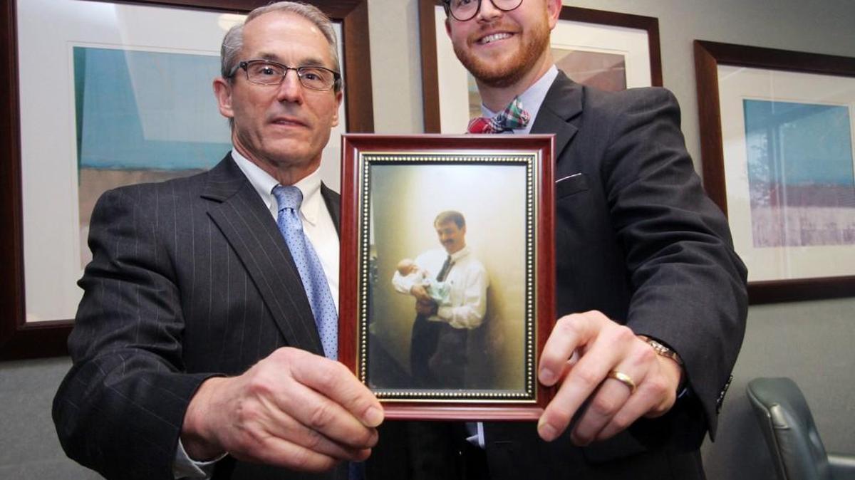 Drs. William Revell, left, and Gerald Ray Comer show off a photo of Revell holding Comer after he was born. The two doctors work together as gynecologists and obstetricians at Piedmont GYN-OB.