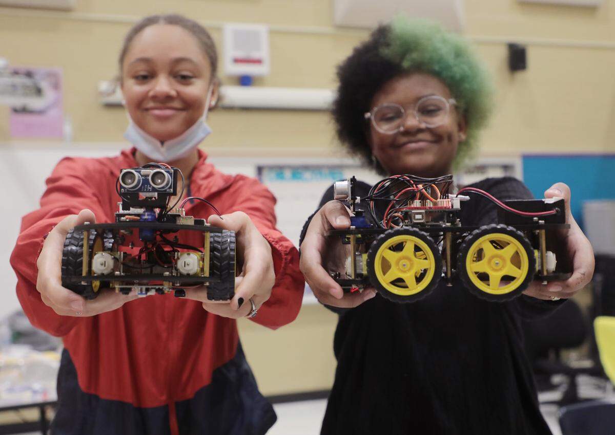 Sisters Maryam Muhammad, 14, left, and Ilyyas Muhammed, 13, hold cars they built at a summer STEAM program through the Rock Hill School District.