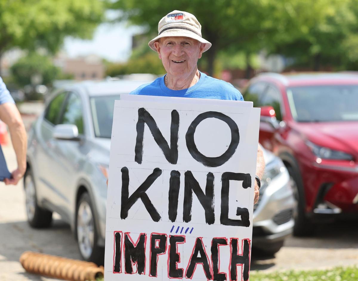 Larry Marriccini holds an anti-Trump sign Saturday at the York County Rising demonstration in downtown Rock Hill.