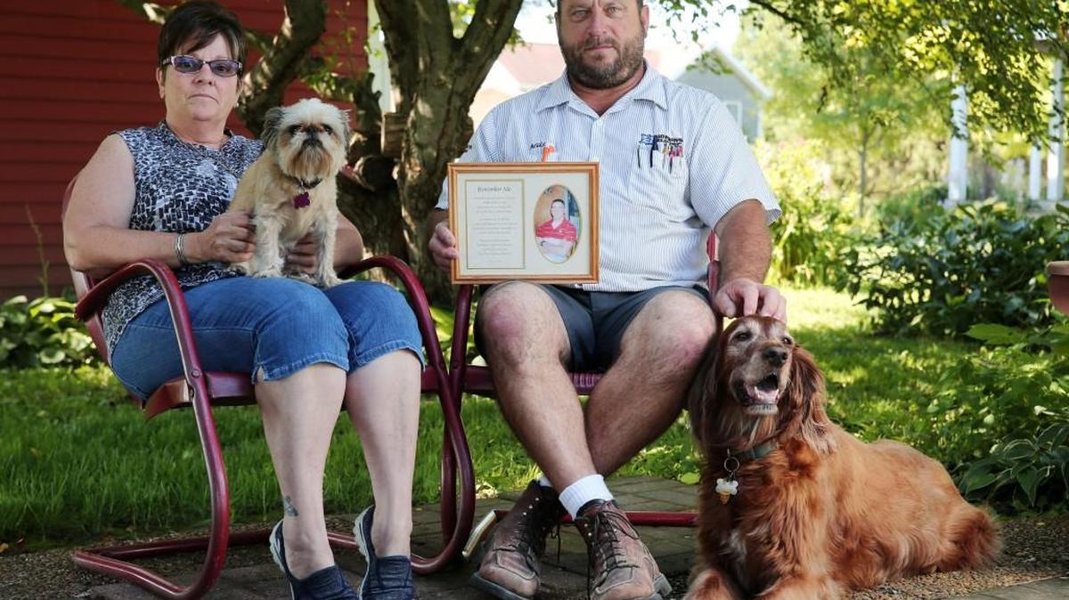 
Kim and Mike Bowman with a framed photo of their son, Timmy Bowman, and two of their dogs, Roxanne, at left, and Cassie, who was a gift from their children, at their home in Forreston, Ill. Timmy Bowman, who suffered from post-traumatic stress disorder, shot himself in the head eight months after returning from National Guard service in Iraq. Cassie was a source of comfort for the Bowmans.
