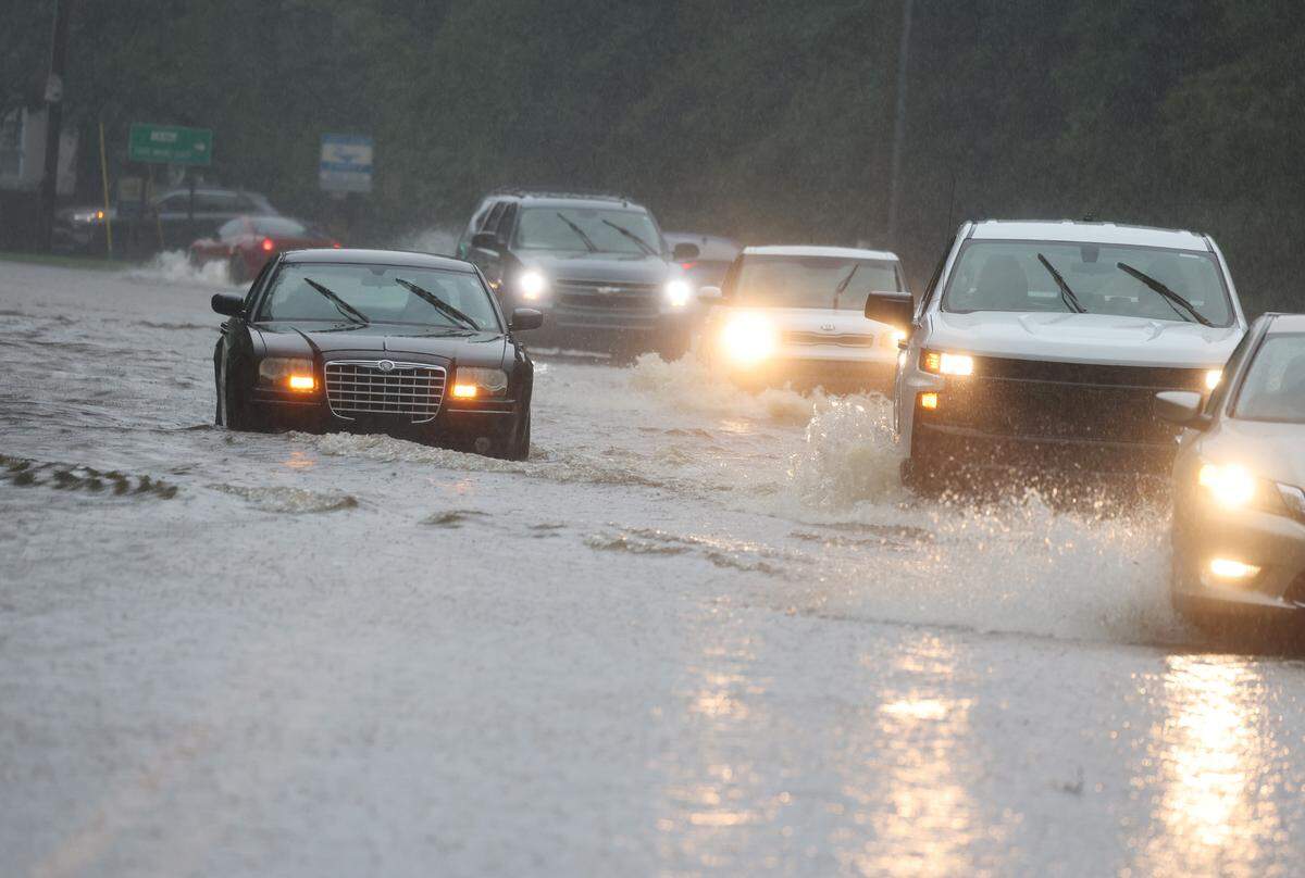 A car stalls in a flooded area at the intersection of Ogden Road and Heckle Blvd. Thursday as Debby dumps rain in the area, and some districts closed school.