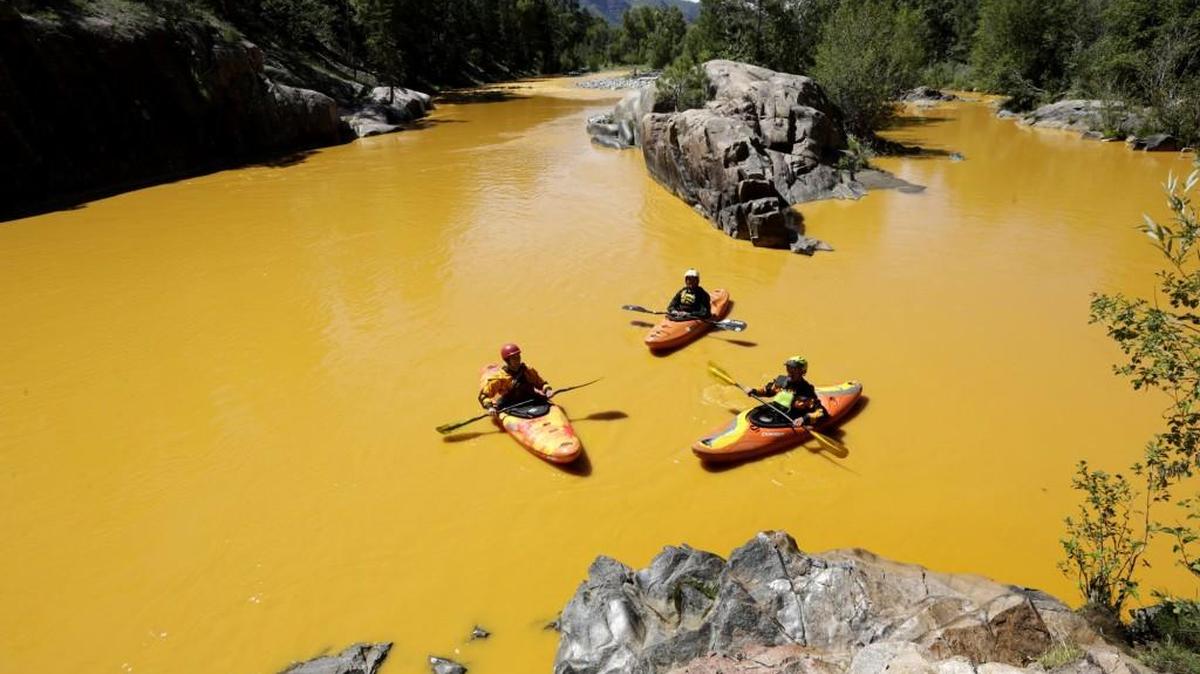 People kayak in the Animas River near Durango, Colo., Aug. 6, 2015, in water colored from a mine waste spill.