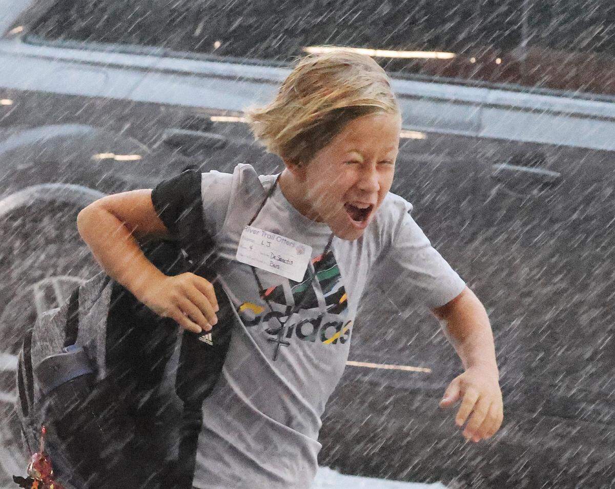 A boy runs through the rain Thursday at River Trail Elementary school. Thursday was the first day of school for the Fort Mill and Rock Hill school districts despite Debby dumping lots of rain into the area.