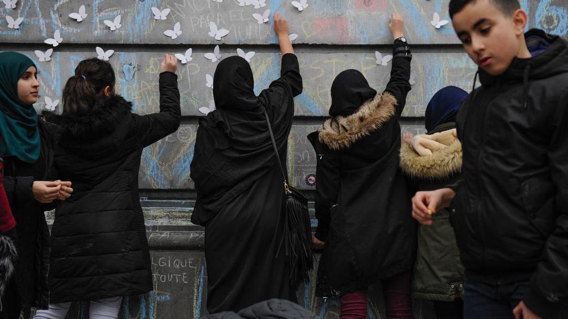 People in the Place de la Bourse, a traditional gathering place in the Belgian capital, write tributes to the victims of Tuesday’s terrorist attacks, which killed at least 31.