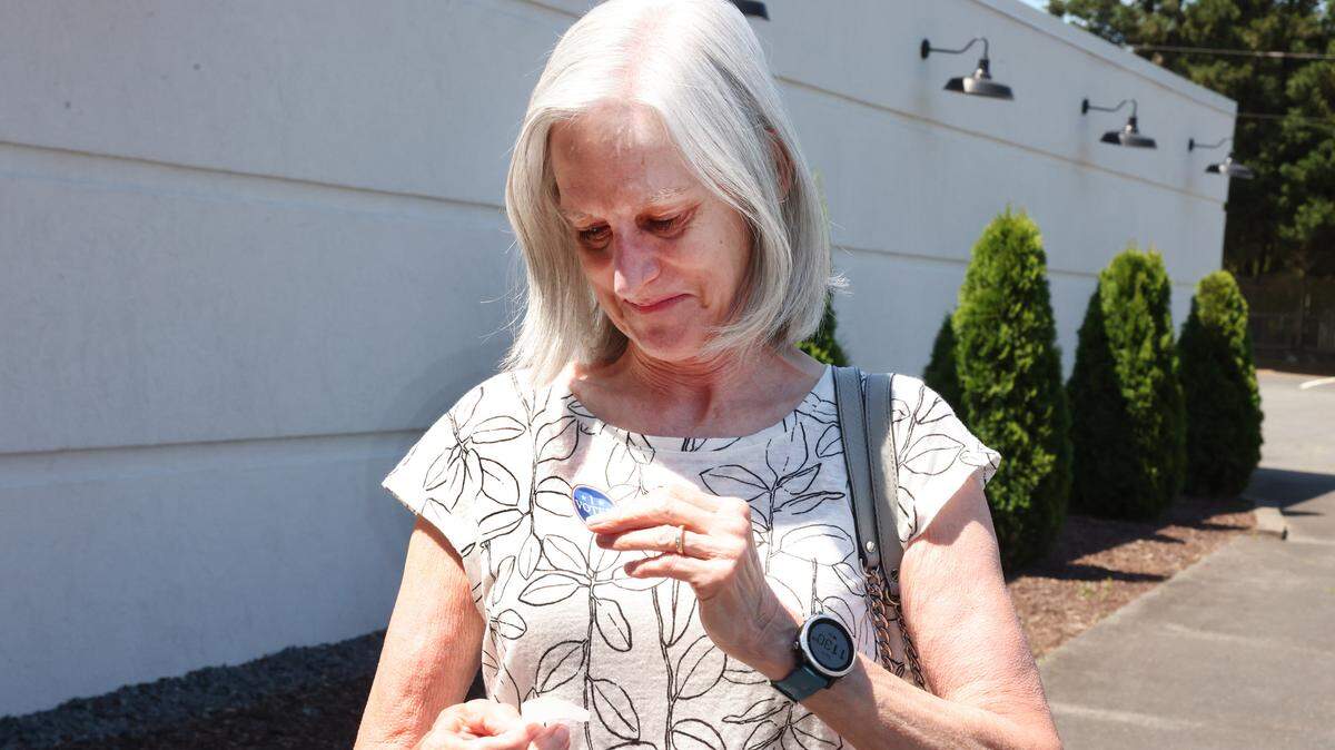 Mary Lewis afixes an “I voted” sticker to her shirt after voting in Tega Cay on Tuesday.
