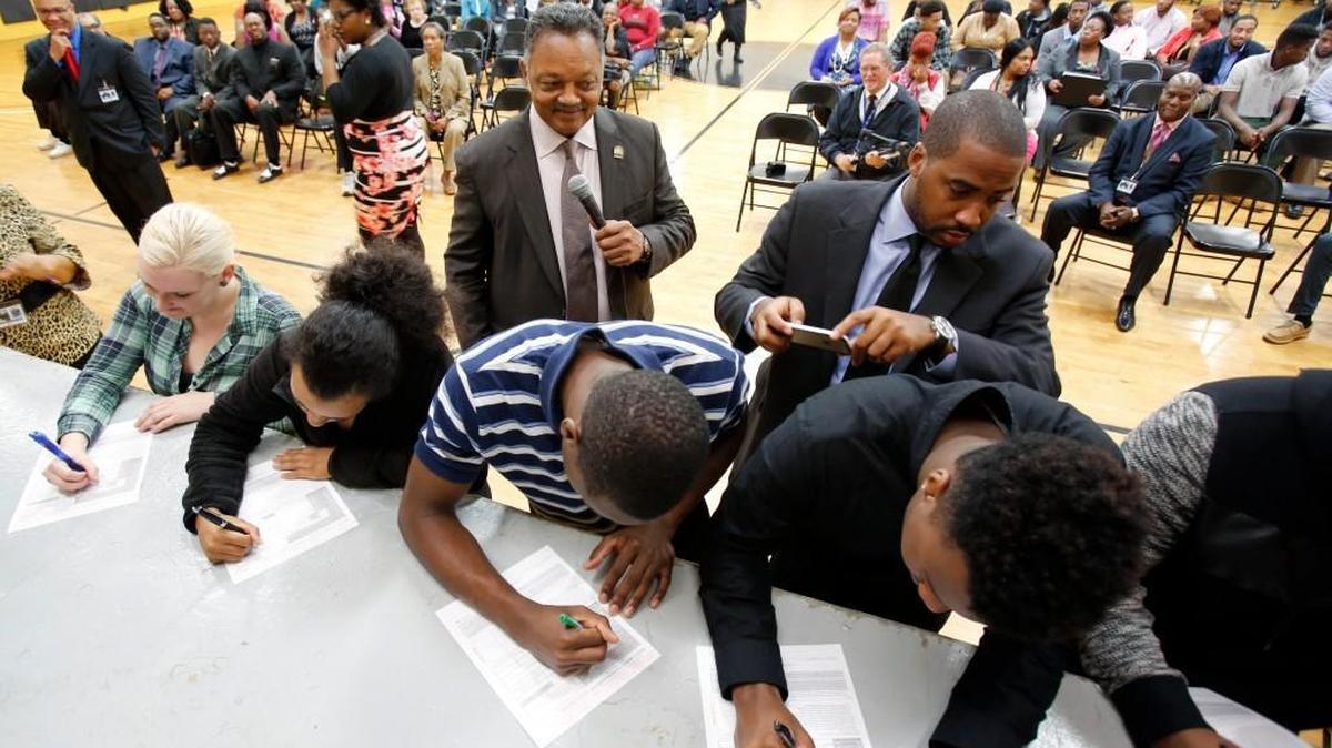 Rev. Jesse Jackson, center, watches as students fill out voter registration forms at Clinton College in Rock Hill Wednesday.