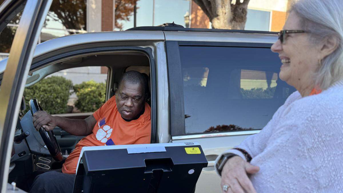 Lawrence Sanders votes curbside while Pat Swoope assists Tuesday, Nov. 4, 2025 in Rock Hill, S.C.